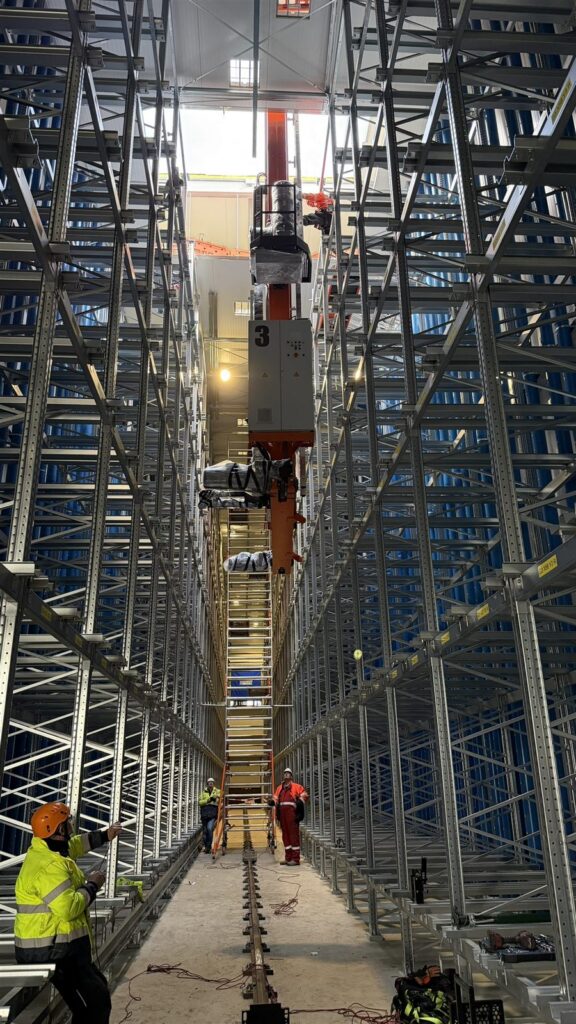 Montage van een magazijnkraan in het stellingwerk